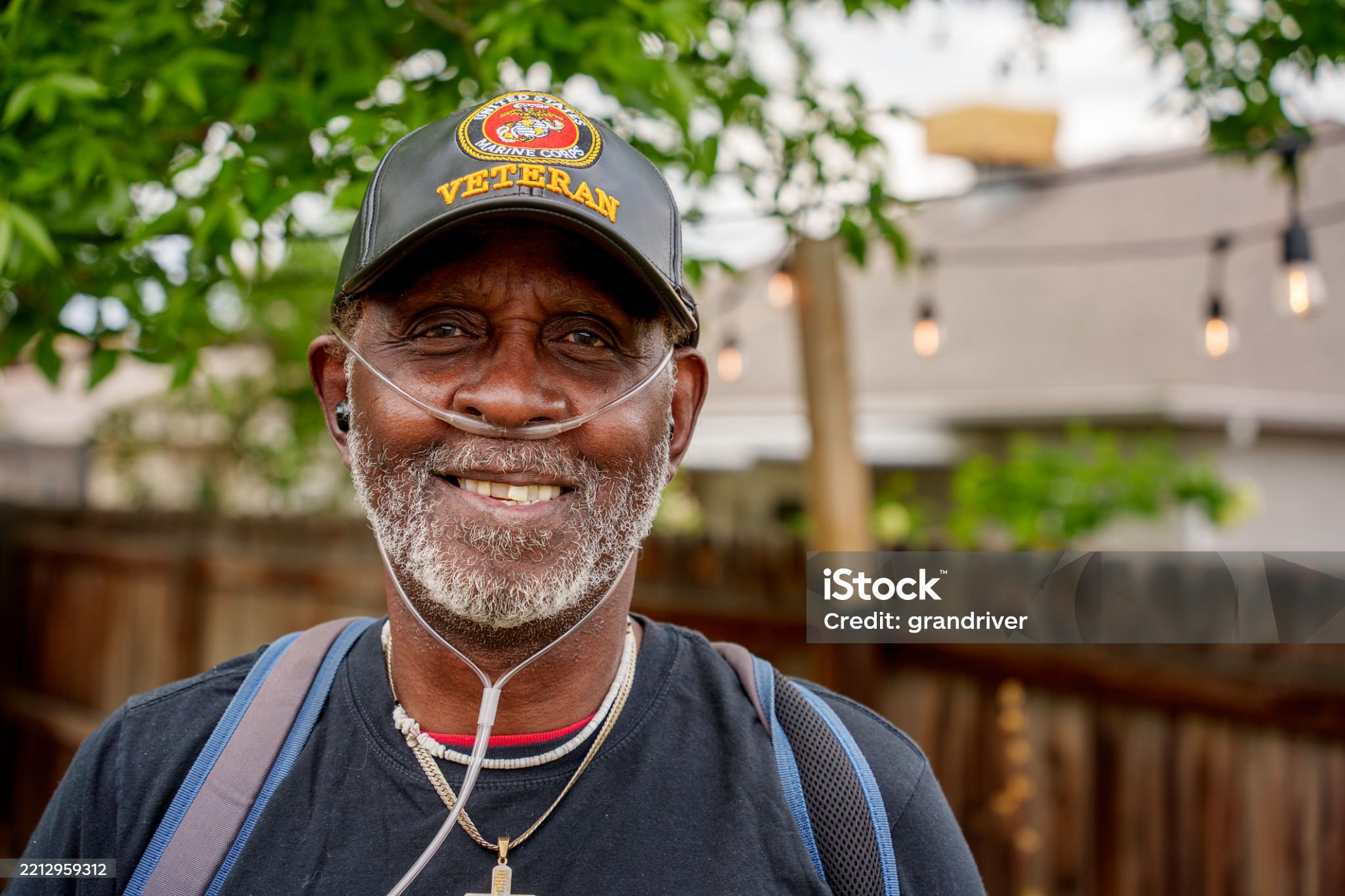 Smiling veteran wearing a Marine Corps veteran hat
